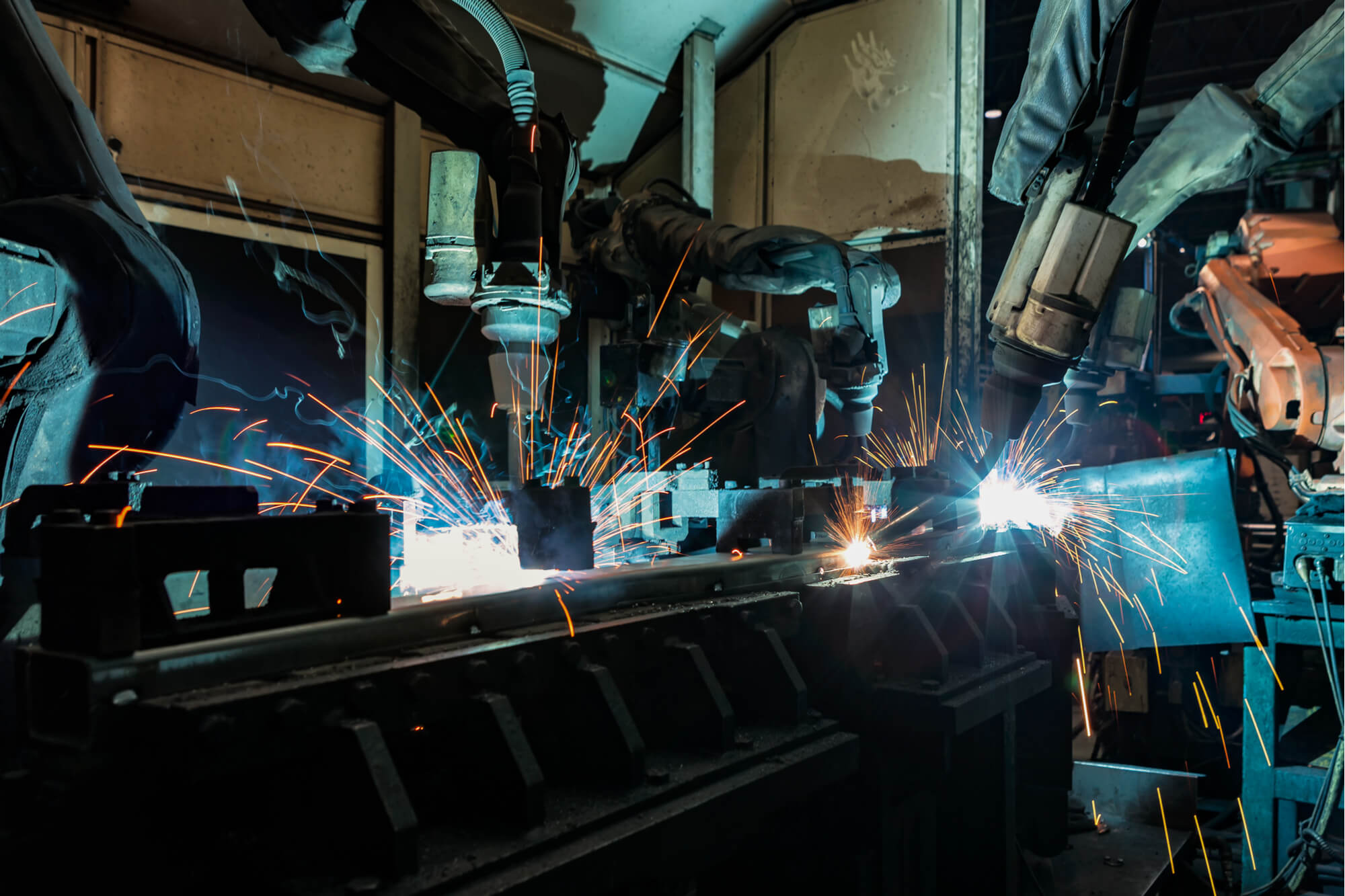Industrial robots are welding metal part in factory